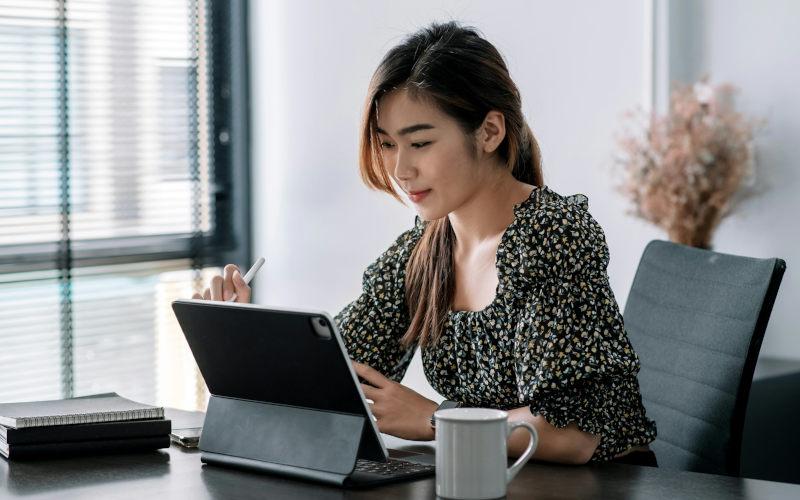 Künstliche Intelligenz ist im Berufsleben dieser jungen Frau mit einem smarten Notebook vor ihr auf dem Schreibtisch bereits Alltag.